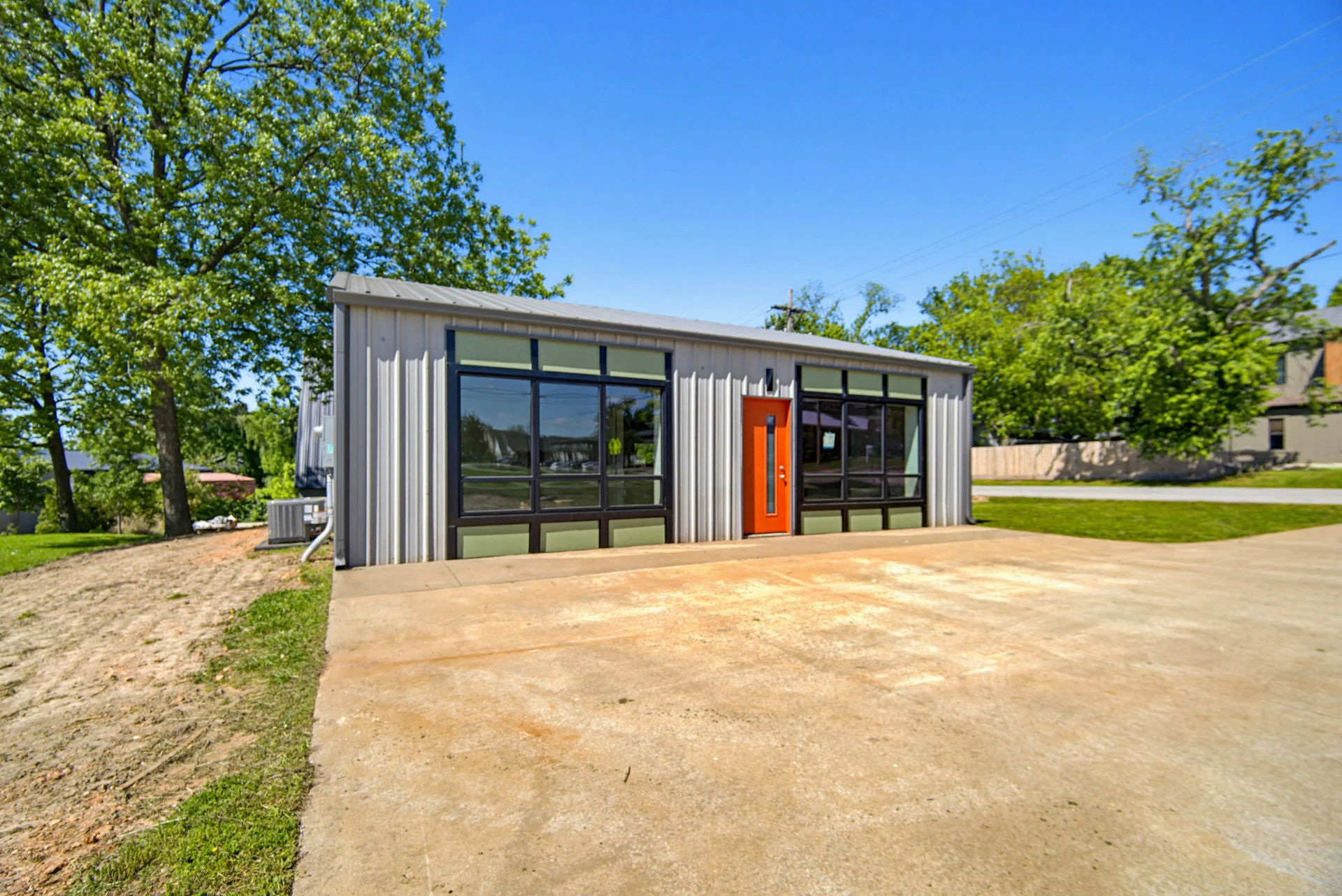 Contemporary exterior with metal siding and a bright entry door