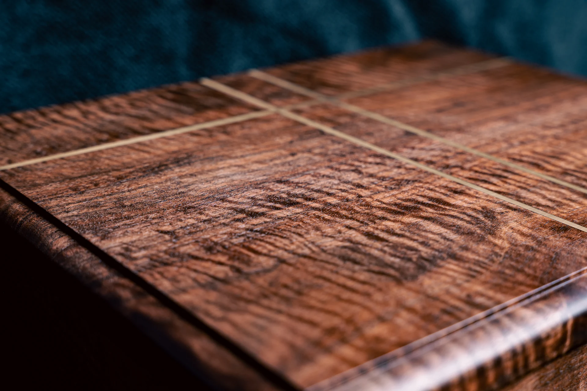 Close-up of the figured wood grain and fine lid inlay