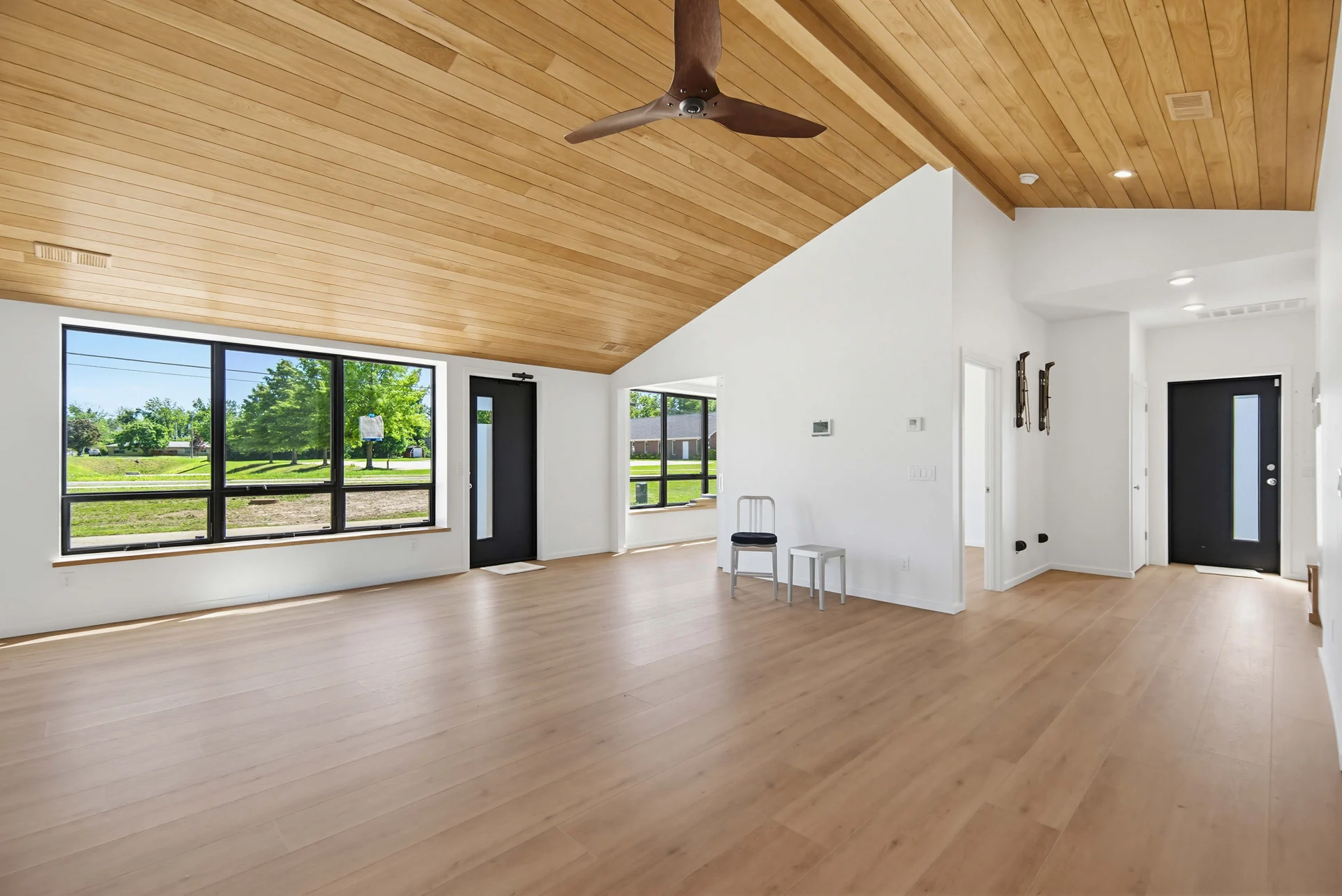 Open living space with a wood ceiling and dark-framed windows