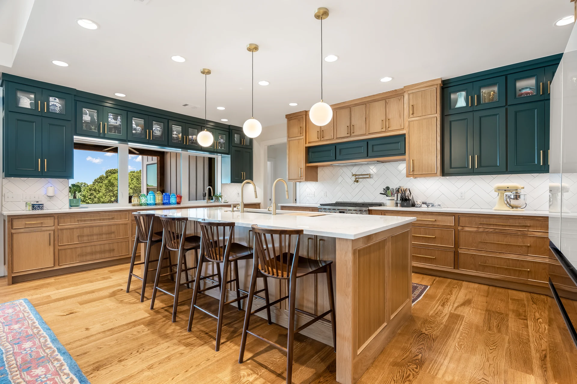 Natural wood kitchen island with blue-green upper cabinetry
