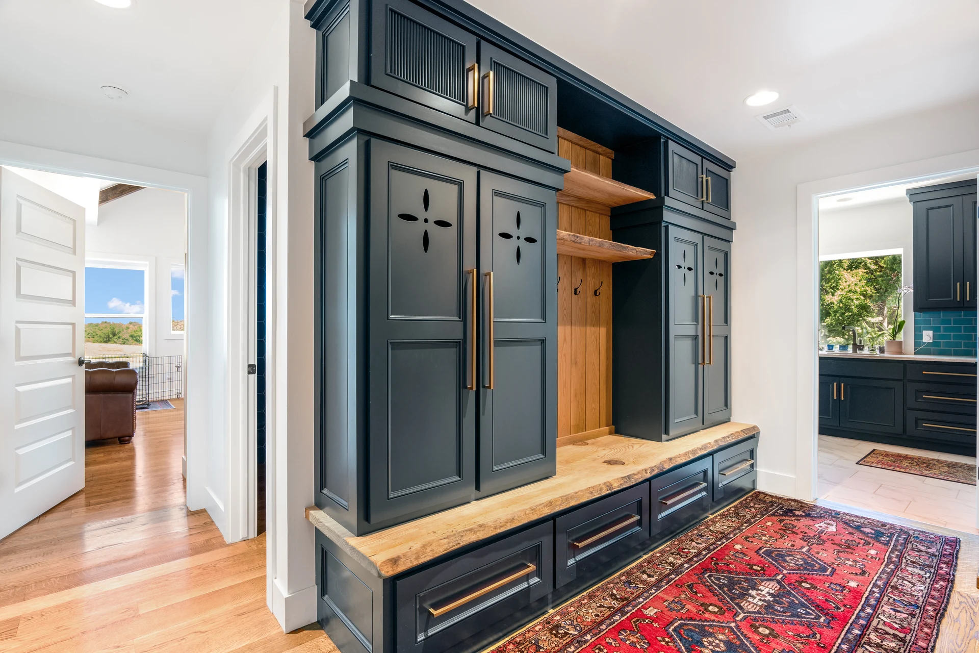 Entry bench framed by deep blue-green built-in storage