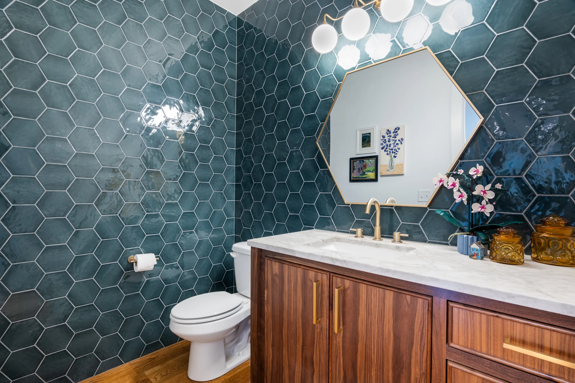 Powder room with blue hexagonal tile and a wood vanity