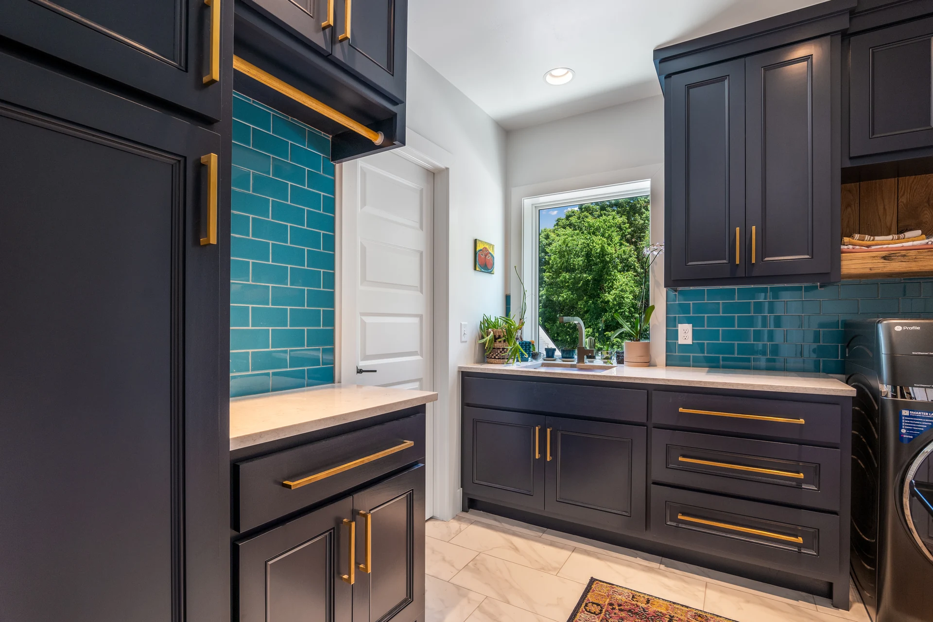 Laundry room cabinetry with a blue tile backsplash