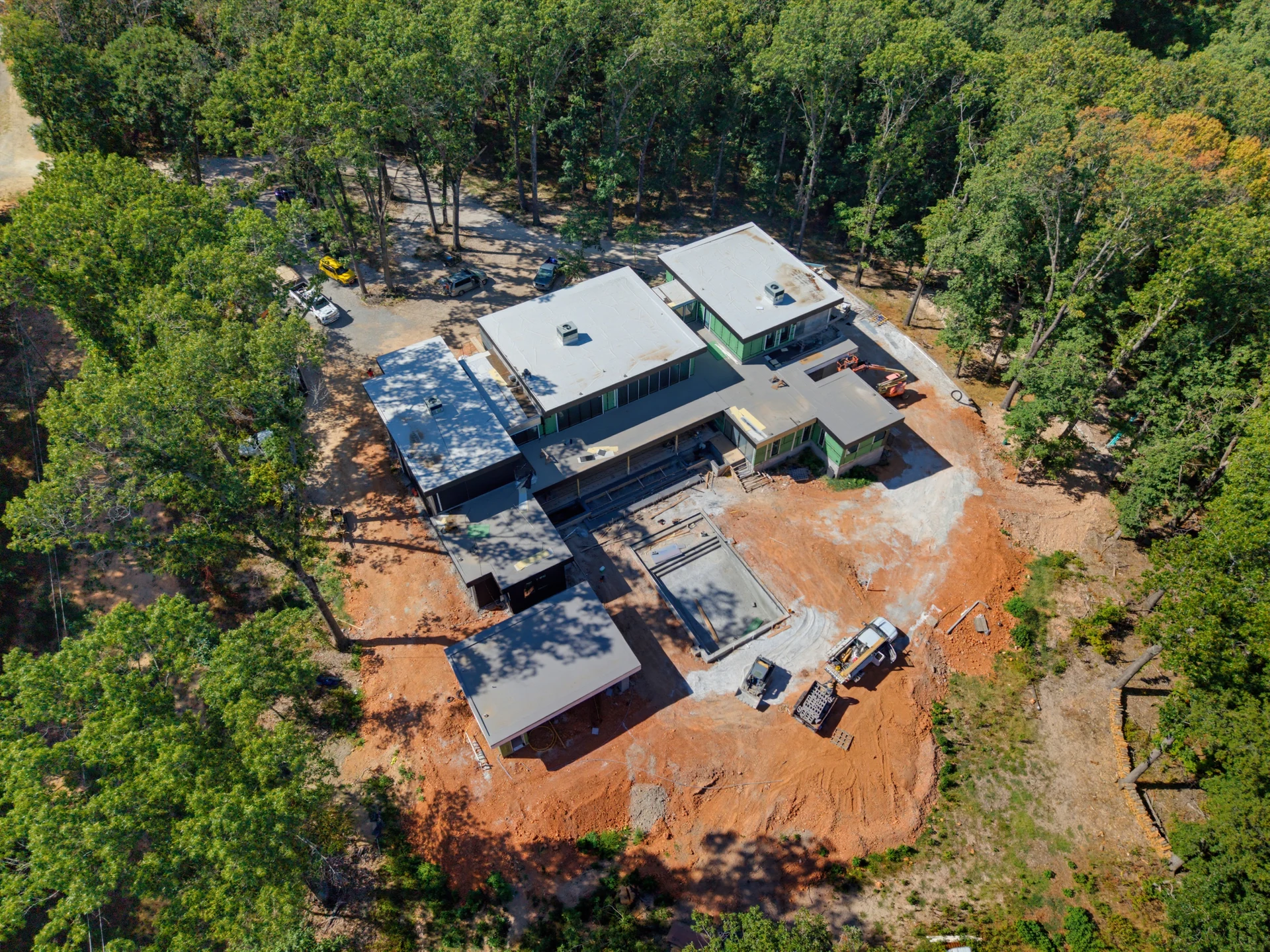 Aerial view of a home under construction within a wooded site