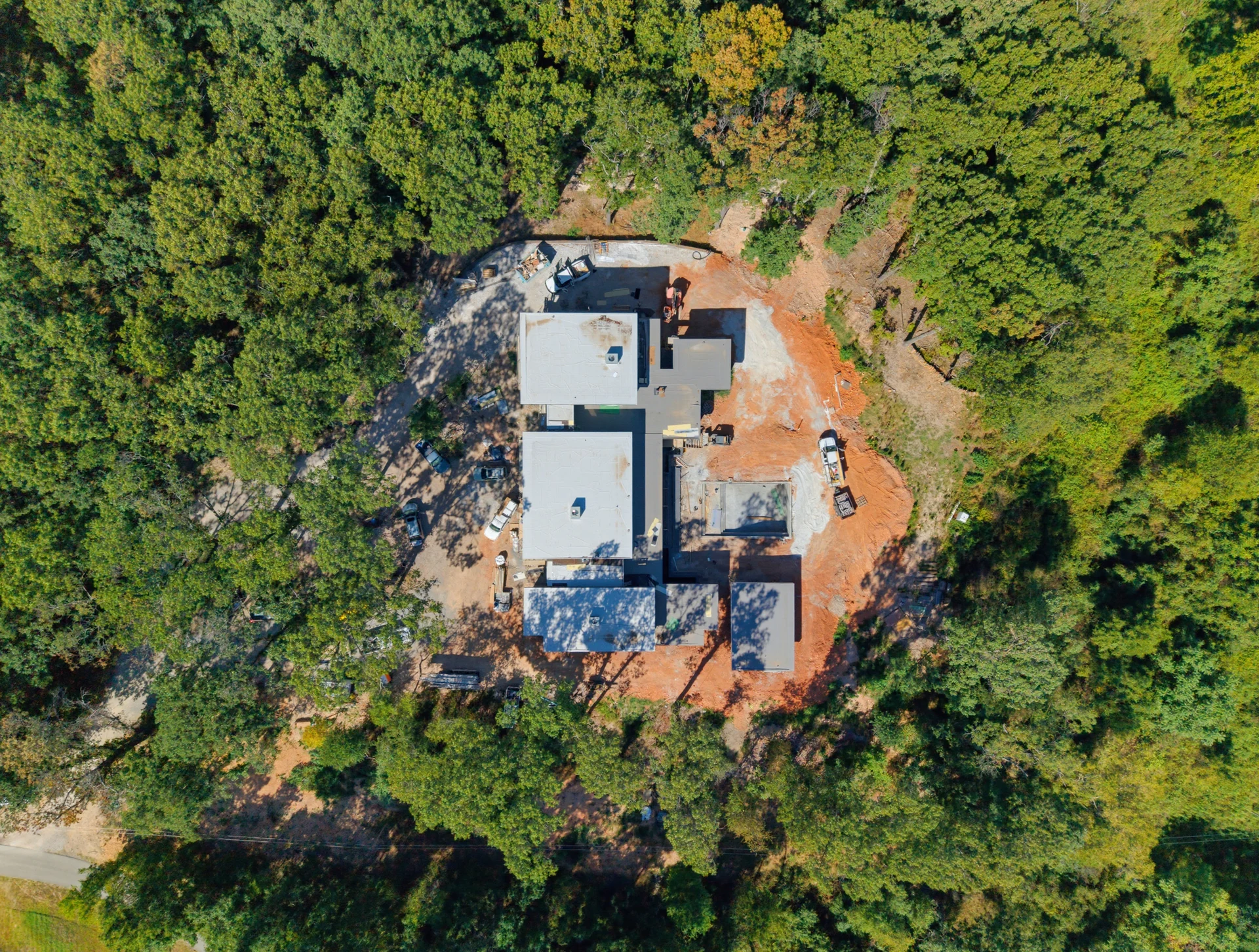 The building site surrounded by a dense tree canopy